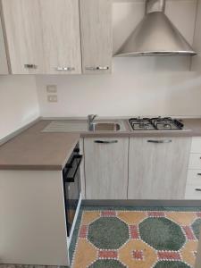 a kitchen with a stove and a sink at Casa Vacanze Lu Trappitu in Magliano