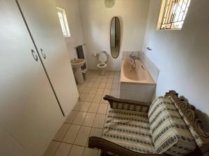 Un baño con bañera, lavabo e inodoro. en Vanross Self Catering Accommodation, en Thabazimbi 6 fotos más
