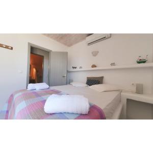a bedroom with two beds with towels on the bed at SIRENA in Kithnos