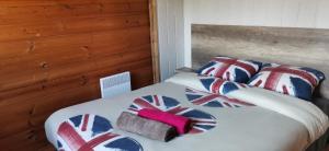 a bedroom with a bed with union jack pillows at Chalet en bois "Le Libellule" in Sigean