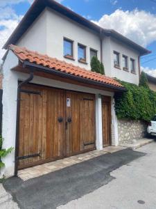 a house with wooden garage doors in a driveway at Apartment Ajna in Sarajevo