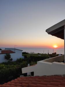 una puesta de sol sobre el océano desde una casa en B&B Stella Maris, en Magomadas