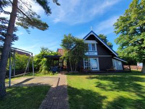 a house with a soccer ball in the yard at Waterfront Villa Artvė with sauna - self check-in in Pervalka