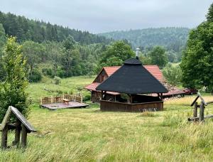 a building with a black roof in a field at Krzywa 19 in Sękowa