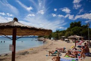 a group of people laying on a beach at Apartman Marijana in Pakoštane