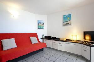 sala de estar con sofá rojo y TV en Appartement des Marées - Welkeys, en Bidart