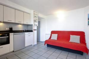 cocina con sofá rojo en una habitación en Appartement des Marées - Welkeys, en Bidart