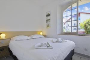ein Schlafzimmer mit einem großen weißen Bett mit Handtüchern darauf in der Unterkunft Wonderful apartment with direct access to the beach - Bidart - Welkeys in Bidart