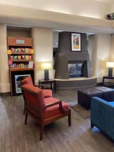 a living room with a chair and a fireplace at Comfort Suites Peoria Sports Complex in Peoria