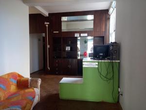 a living room with a tv on a green counter at Casa do Juá 2 in Lavras