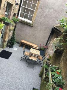 a patio with a table and chairs in front of a building at Cosy cottage in the heart of Bakewell in Bakewell