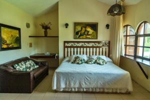 ein Schlafzimmer mit einem Bett und einer Couch darin in der Unterkunft Villablanca Garden Beach Hotel in Cozumel + 147 Fotos