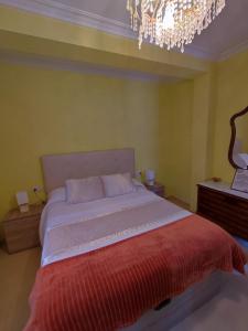 1 dormitorio con 1 cama grande y lámpara de araña en Casa Felisa, Vivienda de uso Turístico, en Finisterre