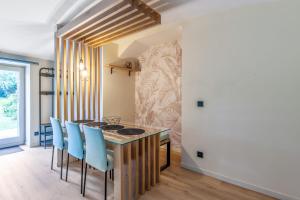 a dining room with a table and blue chairs at Appartement - Château de Beuzeval - Welkeys in Houlgate