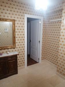 a bathroom with a mirror and a sink at Apartamento Costa Riazor Coruña in A Coruña