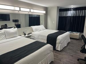 una habitación de hotel con 2 camas y una habitación con en Crystal Inn en Port Arthur