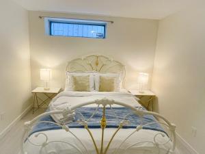 a white bed in a bedroom with two lamps at Adorable 2-Bedroom Basement in Vancouver in Vancouver