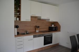 a kitchen with white cabinets and a sink at Zimmervermietung Familie Glatz in Möderbrugg