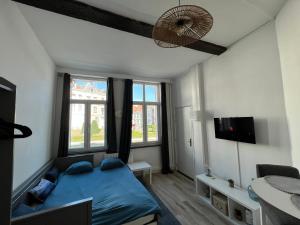 um quarto com uma cama azul e 2 janelas em * Lasuite #1 BLUE * em Valenciennes