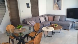 a living room with a couch and tables at Zefyros Suite , Seafront retreat ! in Panormos Rethymno
