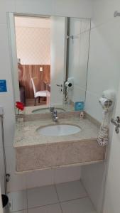 y baño con lavabo y espejo. en Flat Particular - próx Assembleia Leg MT, en Cuiabá