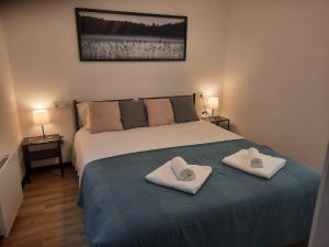 una camera da letto con un letto e due asciugamani di Casa en vigo a 5 min playas a Vigo