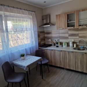 cocina con mesa, sillas y fregadero en Hanna Villa Siófok, en Siófok