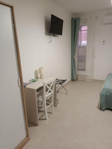 a living room with a table and a tv on the wall at Casetta Nilu' in Procida