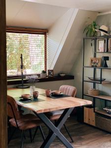 mesa de comedor con sillas y ventana en Mimi's natuurhuisje, en Lanaken