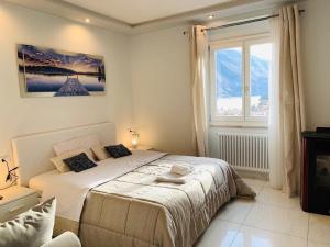 sypialnia z dużym łóżkiem i oknem w obiekcie Dolomia Gioele w mieście Molveno