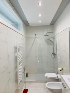 een badkamer met een douche, een toilet en een wastafel bij Dolomia Gioele in Molveno