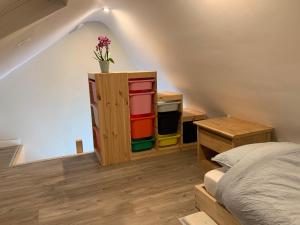a bedroom with a bed and a cabinet with colorful bins at Leeuwerikstraat 9, 8670 Oostduinkerke Groenendijk in Koksijde