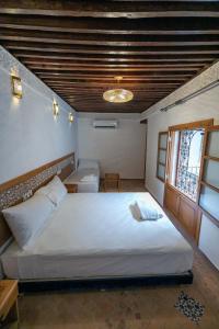 una camera da letto con un grande letto bianco e una finestra di Dar Kenz Fes a Fes