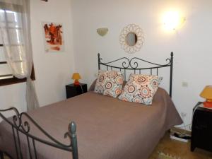 Schlafzimmer mit einem Bett und einem Wandspiegel in der Unterkunft Maison de charme proche mer en Corse du Sud in Sollacaro