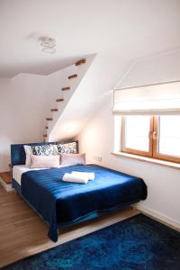 una camera con un letto e una coperta blu di Apartament Ósemka a Mikołajki