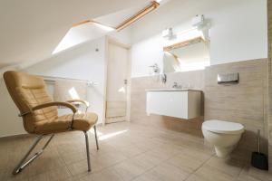 a bathroom with a chair and a toilet and a sink at Villa Magnolia Baltic in Świnoujście +46 photos