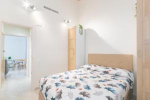 - une chambre dotée d'un lit avec un couvre-lit floral dans l'établissement NICE CITY CENTER APARTMENT, à Vilanova i la Geltrú