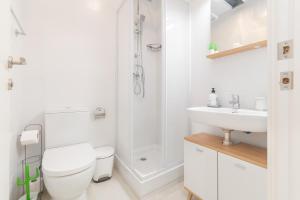 a white bathroom with a toilet and a sink at NICE CITY CENTER APARTMENT in Vilanova i la Geltrú +9 photos