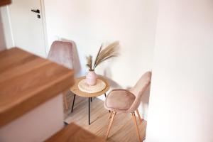 Pokój z 2 krzesłami i stołem z wazą w obiekcie Apartament Ósemka w mieście Mikołajki
