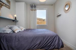 een slaapkamer met een groot bed en een raam bij la p'tite vie là in Le Porge