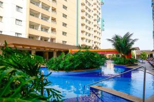 a swimming pool with blue water in a building at Olímpia Resort Joy in Olímpia