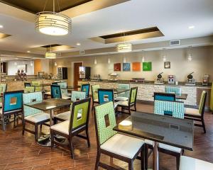 a restaurant with tables and chairs and a bar at Comfort Suites near Tanger Outlet Mall in Gonzales
