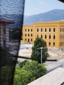 um edifício amarelo com uma rua em frente em Apartment Sunny Bulevar em Mostar