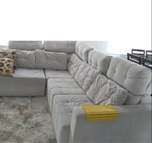 um sofá branco sentado numa sala de estar em Apart Luxo no Centro com hidromassagem em Curitiba