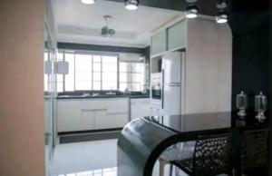uma grande cozinha com armários brancos e um frigorífico em Apart Luxo no Centro com hidromassagem em Curitiba