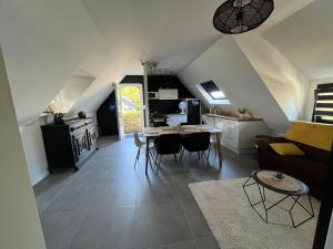ein Wohnzimmer mit einem Sofa und einem Tisch in der Unterkunft Capcoz Les Glycines in Fouesnant