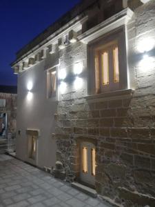 un edificio de piedra con ventanas iluminadas por la noche en La Neviera, en Struda