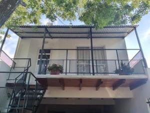 a house with a balcony with plants on it at Departamento Odi in Federación