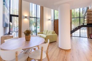 a living room with a table and chairs at Travel Habitat Alameda Suites. in Valencia