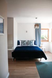 una camera da letto con un grande letto con una coperta blu di Apartament Ósemka a Mikołajki